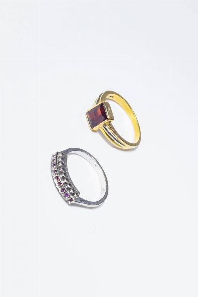 LOTTO DI DUE ANELLI : -in oro giallo con al centro granato taglio ottagonale. Peso gr 4 7. Misura 18 (58) -in oro bianco con fila di rubini taglio rotondo. Peso gr 3 3. Misura 15 (55)  - Asta Gioielli - Associazione Nazionale - Case d'Asta italiane