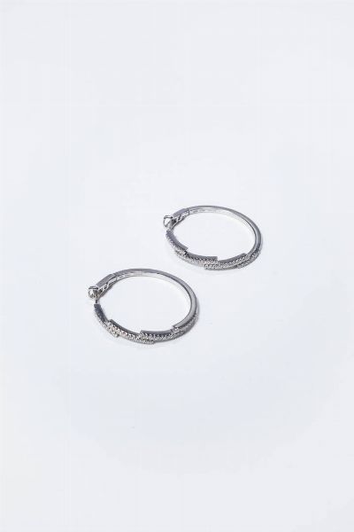 DAMIANI : Peso gr 11 3 Diam. interno cm 3 Coppia di orecchini in oro bianco  a cerchio  firmati Damiani  parte anteriore composta da segmenti sfalsati in diamanti taglio brillante per totali ct 0 60 ca  probabile colore G-H  purezza IF-VVS.  - Asta Gioielli - Associazione Nazionale - Case d'Asta italiane
