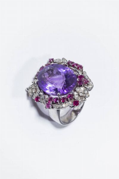 GRANDE ANELLO : Peso gr 20 4 Misura 17 (57) in oro bianco  sommit� con al centro ametista di ct 25 ca  contornata da volute e fiori in diamanti taglio brillante  8/8 per totali ct 0 20 ca e rubini taglio rotondo per totali ct 2 50 ca.  - Asta Gioielli - Associazione Nazionale - Case d'Asta italiane