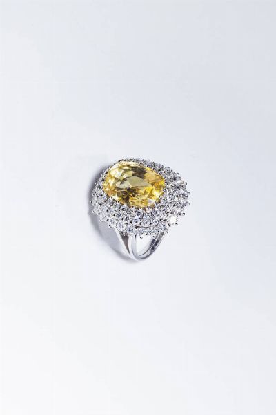 ANELLO : Peso gr 11 1 Misura 12 (52) in oro bianco  al centro zaffiro taglio ovale giallo di ct 10 41 e triplo contorno di diamanti taglio brillante per totali ct 2 40 ca.  - Asta Gioielli - Associazione Nazionale - Case d'Asta italiane