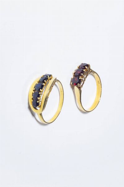 LOTTO DI DUE ANELLI : in oro giallo  composti da: -tre granati taglio rotondo. Peso gr3 1. Misura 17 (57) -cinque zaffiri taglio rotondo a scalare per totali ct 1 0 ca. Peso gr 2 7. Misura 18 (58).  - Asta Gioielli - Associazione Nazionale - Case d'Asta italiane