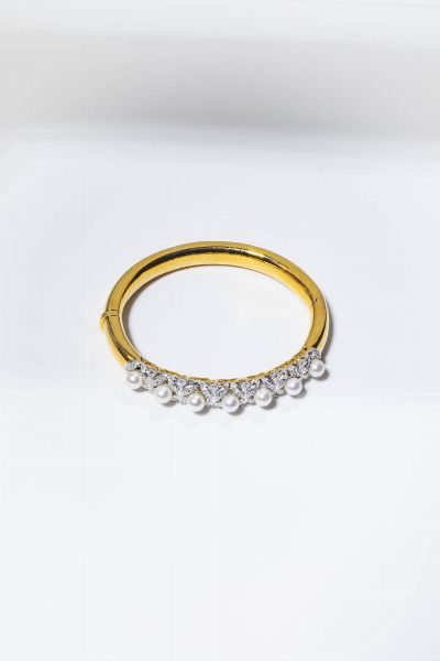 BRACCIALE : Peso gr 33 7 Diam. interno cm 5x5 5 rigido  in oro giallo e bianco  sommit decorata con perle giapponesi del diam. di mm 6 ca e diamanti taglio brillante per totali ct.1 20 ca.  - Asta Gioielli - Associazione Nazionale - Case d'Asta italiane