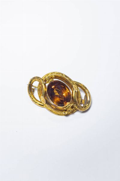 SPILLA : Peso gr 13 3 Cm 4x5 5 in oro rosa 9 Kt  XIX secolo  lavorata ad intreccio  a canna vuota  al centro gemma sintetica nei toni del cognac.  - Asta Gioielli - Associazione Nazionale - Case d'Asta italiane