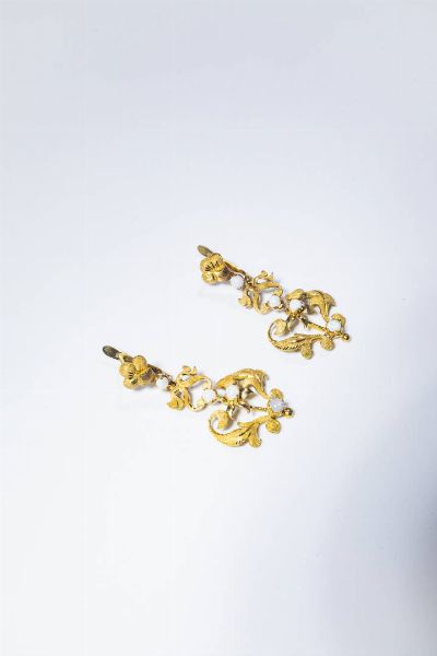 COPPIA DI ORECCHINI : Peso gr 10 2 in oro giallo  anni '50  a volute satinate con opali bianchi.  - Asta Gioielli - Associazione Nazionale - Case d'Asta italiane