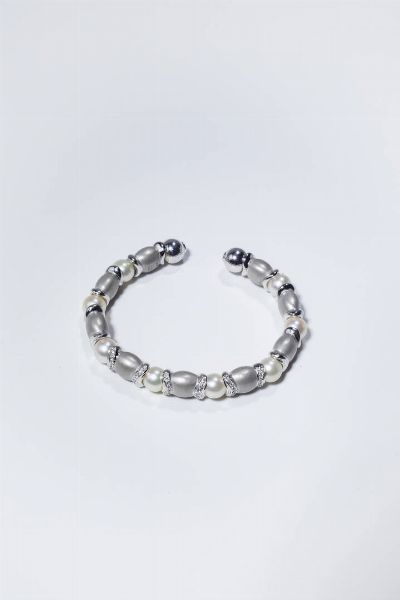 BRACCIALE : Peso gr 26 3 rigido  in oro bianco  sommit con segmenti satinati alternati a perle giapponesi del diam. di mm 8 ca e diamanti taglio brillante per totali ct 0 30 ca.  - Asta Gioielli - Associazione Nazionale - Case d'Asta italiane