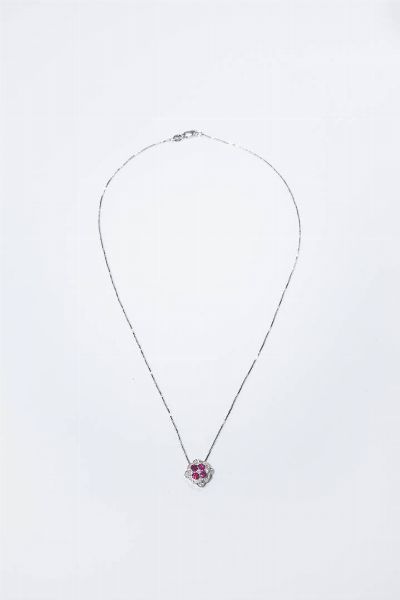 CATENA CON CIONDOLO : Peso gr 4 1 in oro bianco con elemento geometrico in diamanti taglio brillante per totali ct 0 14 ca  probabile colore G-H  purezza IF-VVS e rubini taglio rotondo per totali ct 0 39 ca.  - Asta Gioielli - Associazione Nazionale - Case d'Asta italiane