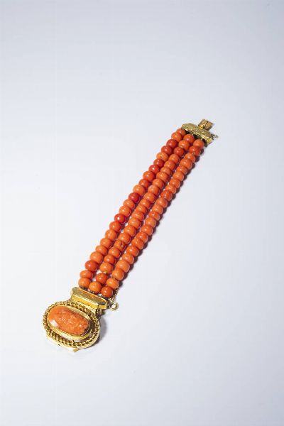 BRACCIALE : Peso gr 50 1 Lunghezza cm 18 XIX secolo  composto da tre fili di dischi di corallo nei toni del salmone; al centro chiusura in oro giallo con punzoni francesi e grande cammeo inciso con ritratto virile. Accompagnato da certificato telematico di autenticit Ce.S.Ar. Centro Studi Archeometrici.  - Asta Gioielli - Associazione Nazionale - Case d'Asta italiane