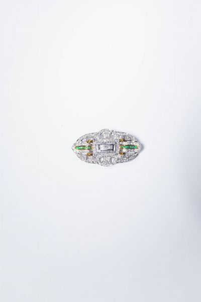SPILLA : Peso gr 16 2 Cm 2 5x4 5 in oro bianco  in stile Dco  di forma rettangolare con angoli ovalizzati con diamanti taglio brillante e princess per totali ct 1 30 ca e smeraldi taglio carr per totali ct 0 25 ca.  - Asta Gioielli - Associazione Nazionale - Case d'Asta italiane