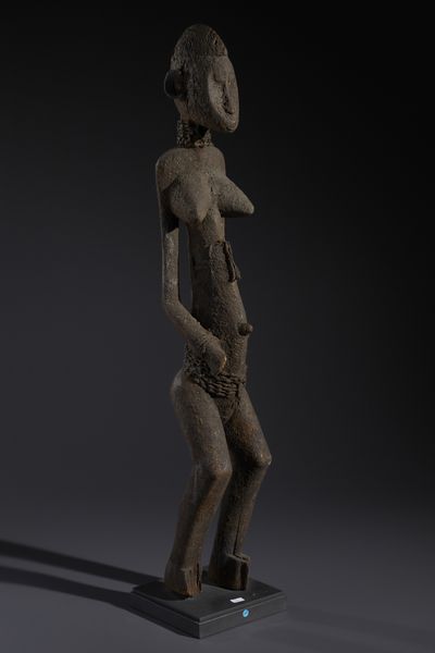Senufo - Costa d'Avorio/Mali/Burkina Faso : Nello stile di Grande scultura antropomorfa in legno a patina nera crostosa e fibre  - Asta Asta 444 | AFRICA, OCEANIA E AMERICHE - ARTIGIANATO AFRICANO: VARI COMMITTENTI E SELEZIONE DALLA COLLEZIONE BARTOLOMUCCI Online - Associazione Nazionale - Case d'Asta italiane