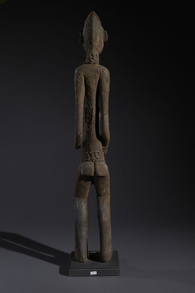 Senufo - Costa d'Avorio/Mali/Burkina Faso : Nello stile di Grande scultura antropomorfa in legno a patina nera crostosa e fibre  - Asta Asta 444 | AFRICA, OCEANIA E AMERICHE - ARTIGIANATO AFRICANO: VARI COMMITTENTI E SELEZIONE DALLA COLLEZIONE BARTOLOMUCCI Online - Associazione Nazionale - Case d'Asta italiane