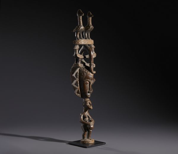 Guro - Costa d'Avorio : Nello stile di Maschera con elaborata acconciatura decorata con figure di uccelli e con  sostegno in forma di scultura antropomorfa Legno duro a patina marrone  - Asta Asta 444 | AFRICA, OCEANIA E AMERICHE - ARTIGIANATO AFRICANO: VARI COMMITTENTI E SELEZIONE DALLA COLLEZIONE BARTOLOMUCCI Online - Associazione Nazionale - Case d'Asta italiane