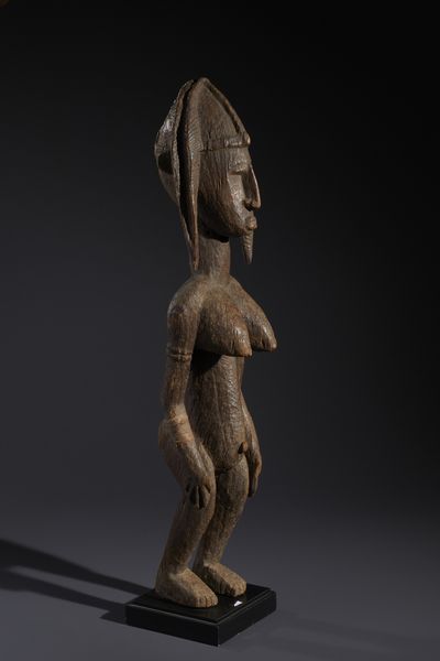 Bambara - Mali : Nello stile di Grande scultura antropomorfa femminile in legno duro a patina marrone e cordicella  - Asta Asta 444 | AFRICA, OCEANIA E AMERICHE - ARTIGIANATO AFRICANO: VARI COMMITTENTI E SELEZIONE DALLA COLLEZIONE BARTOLOMUCCI Online - Associazione Nazionale - Case d'Asta italiane