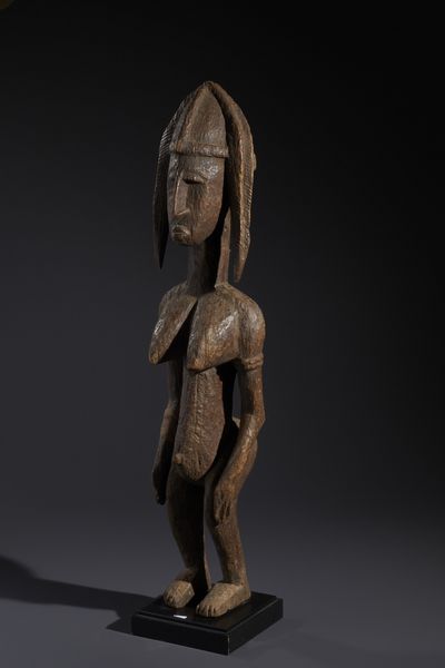 Bambara - Mali : Nello stile di Grande scultura antropomorfa femminile in legno duro a patina marrone e cordicella  - Asta Asta 444 | AFRICA, OCEANIA E AMERICHE - ARTIGIANATO AFRICANO: VARI COMMITTENTI E SELEZIONE DALLA COLLEZIONE BARTOLOMUCCI Online - Associazione Nazionale - Case d'Asta italiane