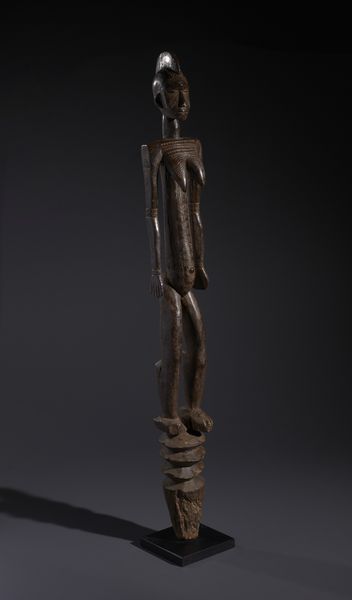 Mossi - Burkina Faso : Nello stile di Grande palo con scultura antropomorfa  in legno duro a patina bruno-rossastra  - Asta Asta 444 | AFRICA, OCEANIA E AMERICHE - ARTIGIANATO AFRICANO: VARI COMMITTENTI E SELEZIONE DALLA COLLEZIONE BARTOLOMUCCI Online - Associazione Nazionale - Case d'Asta italiane