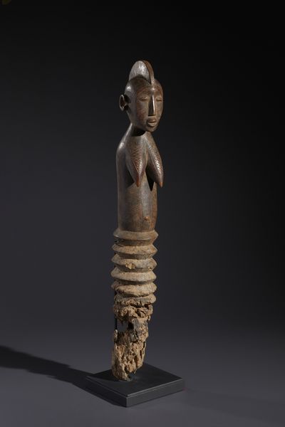 Mossi - Burkina Faso : Nello stile di Grande palo con figura antropomorfa femminile  in legno duro a patina bruno-rossastra  - Asta Asta 444 | AFRICA, OCEANIA E AMERICHE - ARTIGIANATO AFRICANO: VARI COMMITTENTI E SELEZIONE DALLA COLLEZIONE BARTOLOMUCCI Online - Associazione Nazionale - Case d'Asta italiane