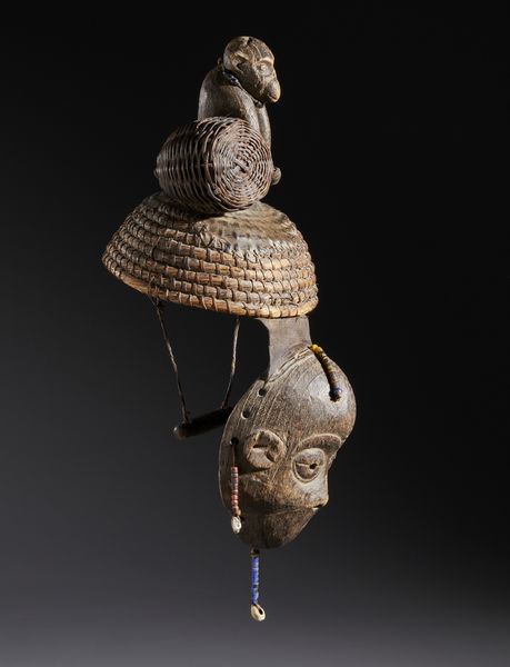 Igbo - Nigeria : Nello stile di Maschera con copricapo sormontato da una scultura di scimmia  in legno a patina scura, fibre,  conchiglie, perline, semi e pelle  - Asta Asta 444 | AFRICA, OCEANIA E AMERICHE - ARTIGIANATO AFRICANO: VARI COMMITTENTI E SELEZIONE DALLA COLLEZIONE BARTOLOMUCCI Online - Associazione Nazionale - Case d'Asta italiane