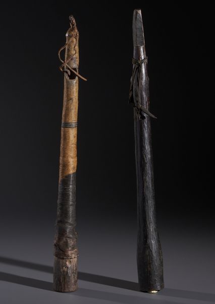 AUTORI VARI : Lotto composto  di due trombe traverse in legno duro a patina scura, fibre e pelle  - Asta Asta 444 | AFRICA, OCEANIA E AMERICHE - ARTIGIANATO AFRICANO: VARI COMMITTENTI E SELEZIONE DALLA COLLEZIONE BARTOLOMUCCI Online - Associazione Nazionale - Case d'Asta italiane