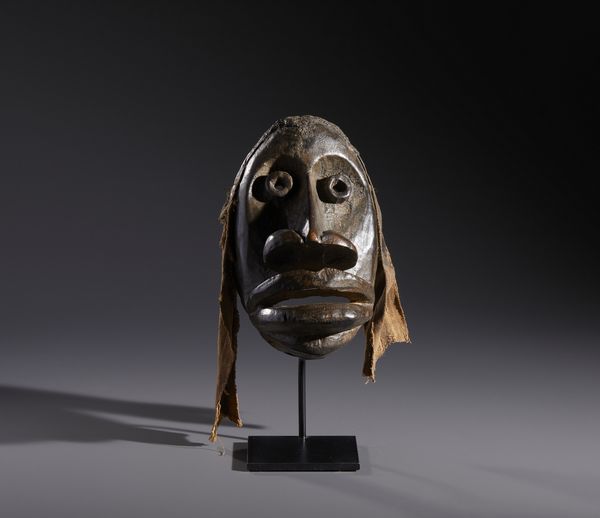 Dan - Costa d'Avorio/Liberia : Nello stile di Maschera antropomorfa  in legno a patina marrone e fibre  - Asta Asta 444 | AFRICA, OCEANIA E AMERICHE - ARTIGIANATO AFRICANO: VARI COMMITTENTI E SELEZIONE DALLA COLLEZIONE BARTOLOMUCCI Online - Associazione Nazionale - Case d'Asta italiane