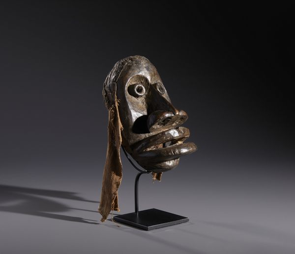 Dan - Costa d'Avorio/Liberia : Nello stile di Maschera antropomorfa  in legno a patina marrone e fibre  - Asta Asta 444 | AFRICA, OCEANIA E AMERICHE - ARTIGIANATO AFRICANO: VARI COMMITTENTI E SELEZIONE DALLA COLLEZIONE BARTOLOMUCCI Online - Associazione Nazionale - Case d'Asta italiane