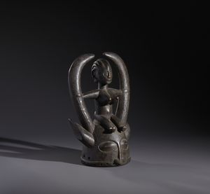 Senufo - Costa d'Avorio/Mali/Burkina Faso : Nello stile di Maschera a casco con personaggio antropomorfo seduto in legno duro a patina nera  - Asta Asta 444 | AFRICA, OCEANIA E AMERICHE - ARTIGIANATO AFRICANO: VARI COMMITTENTI E SELEZIONE DALLA COLLEZIONE BARTOLOMUCCI Online - Associazione Nazionale - Case d'Asta italiane