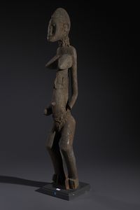 Senufo - Costa d'Avorio/Mali/Burkina Faso : Nello stile di Grande scultura antropomorfa in legno a patina nera crostosa e fibre  - Asta Asta 444 | AFRICA, OCEANIA E AMERICHE - ARTIGIANATO AFRICANO: VARI COMMITTENTI E SELEZIONE DALLA COLLEZIONE BARTOLOMUCCI Online - Associazione Nazionale - Case d'Asta italiane
