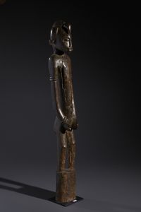 Senufo - Costa d'Avorio/Mali/Burkina Faso : Nello stile di Grande scultura antropomorfa su basamento  in legno duro a patina marrone  - Asta Asta 444 | AFRICA, OCEANIA E AMERICHE - ARTIGIANATO AFRICANO: VARI COMMITTENTI E SELEZIONE DALLA COLLEZIONE BARTOLOMUCCI Online - Associazione Nazionale - Case d'Asta italiane