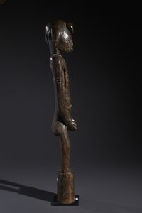 Senufo - Costa d'Avorio/Mali/Burkina Faso : Nello stile di Grande scultura antropomorfa su basamento  in legno duro a patina marrone  - Asta Asta 444 | AFRICA, OCEANIA E AMERICHE - ARTIGIANATO AFRICANO: VARI COMMITTENTI E SELEZIONE DALLA COLLEZIONE BARTOLOMUCCI Online - Associazione Nazionale - Case d'Asta italiane