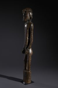 Senufo - Costa d'Avorio/Mali/Burkina Faso : Nello stile di Grande scultura antropomorfa su basamento  in legno duro a patina marrone  - Asta Asta 444 | AFRICA, OCEANIA E AMERICHE - ARTIGIANATO AFRICANO: VARI COMMITTENTI E SELEZIONE DALLA COLLEZIONE BARTOLOMUCCI Online - Associazione Nazionale - Case d'Asta italiane