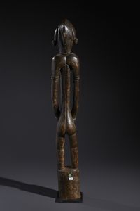 Senufo - Costa d'Avorio/Mali/Burkina Faso : Nello stile di Grande scultura antropomorfa su basamento  in legno duro a patina marrone  - Asta Asta 444 | AFRICA, OCEANIA E AMERICHE - ARTIGIANATO AFRICANO: VARI COMMITTENTI E SELEZIONE DALLA COLLEZIONE BARTOLOMUCCI Online - Associazione Nazionale - Case d'Asta italiane
