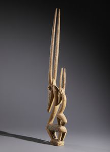 Bambara - Mali : Nello stile di Scultura-cimieoi Cywara  in forma di  antilopi in legno duro a patina naturale, tessuto e lamiera  - Asta Asta 444 | AFRICA, OCEANIA E AMERICHE - ARTIGIANATO AFRICANO: VARI COMMITTENTI E SELEZIONE DALLA COLLEZIONE BARTOLOMUCCI Online - Associazione Nazionale - Case d'Asta italiane