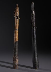 AUTORI VARI : Lotto composto  di due trombe traverse in legno duro a patina scura, fibre e pelle  - Asta Asta 444 | AFRICA, OCEANIA E AMERICHE - ARTIGIANATO AFRICANO: VARI COMMITTENTI E SELEZIONE DALLA COLLEZIONE BARTOLOMUCCI Online - Associazione Nazionale - Case d'Asta italiane
