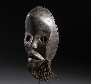 Dan - Costa d'Avorio/Liberia : Nello stile di Maschera antropomorfa in legno duro a patina scura, metallo e fibre  - Asta Asta 444 | AFRICA, OCEANIA E AMERICHE - ARTIGIANATO AFRICANO: VARI COMMITTENTI E SELEZIONE DALLA COLLEZIONE BARTOLOMUCCI Online - Associazione Nazionale - Case d'Asta italiane