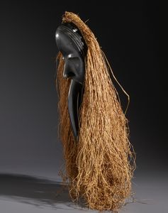 Dan - Costa d'Avorio/Liberia : Nello stile di Maschera antropomorfa con becco in legno duro a patina nera e raffia  - Asta Asta 444 | AFRICA, OCEANIA E AMERICHE - ARTIGIANATO AFRICANO: VARI COMMITTENTI E SELEZIONE DALLA COLLEZIONE BARTOLOMUCCI Online - Associazione Nazionale - Case d'Asta italiane