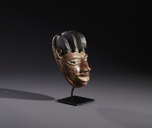 Yoruba -Nigeria : Nello stile diMaschera antropomorfa in legno a patina marrone  e pigmenti  - Asta Asta 444 | AFRICA, OCEANIA E AMERICHE - ARTIGIANATO AFRICANO: VARI COMMITTENTI E SELEZIONE DALLA COLLEZIONE BARTOLOMUCCI Online - Associazione Nazionale - Case d'Asta italiane