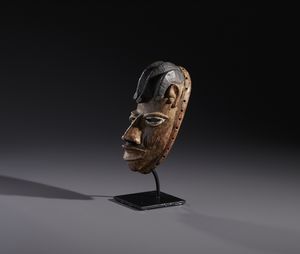 Yoruba -Nigeria : Nello stile diMaschera antropomorfa in legno a patina marrone  e pigmenti  - Asta Asta 444 | AFRICA, OCEANIA E AMERICHE - ARTIGIANATO AFRICANO: VARI COMMITTENTI E SELEZIONE DALLA COLLEZIONE BARTOLOMUCCI Online - Associazione Nazionale - Case d'Asta italiane