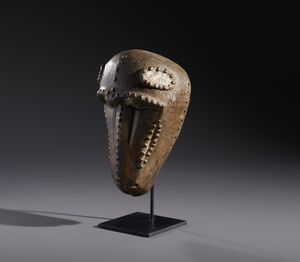 Baule - Costa d'Avorio : Nello stile di Maschera zoomorfa  in legno duro a patina marrone, caolino e metallo  - Asta Asta 444 | AFRICA, OCEANIA E AMERICHE - ARTIGIANATO AFRICANO: VARI COMMITTENTI E SELEZIONE DALLA COLLEZIONE BARTOLOMUCCI Online - Associazione Nazionale - Case d'Asta italiane