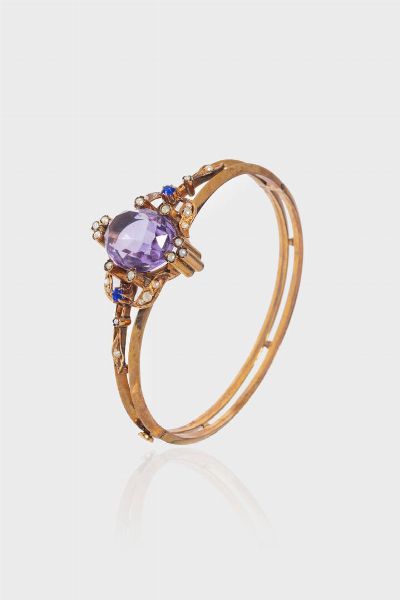 BRACCIALE : Peso gr 16 1 Diam. interno 5 8x5 2 rigido  in oro rosa  a bassa caratura  XIX secolo  sommit� con gemma sintetica viola  perline e due gemme sintetiche blu a decoro  - Asta Gioielli - Associazione Nazionale - Case d'Asta italiane