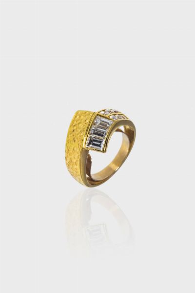 ANELLO : Peso gr 8.8 Misura 18 (58) in oro giallo liscio e satinato  modello contrari  con diamanti taglio baguette e brillante per totali ct 1 60 ca  probabile colore G. purezza VVS-VS Presente molletta interna di ristringimento in oro a bassa caratura.  - Asta Gioielli - Associazione Nazionale - Case d'Asta italiane