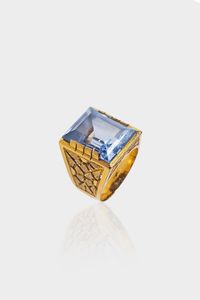 ANELLO - Peso gr 11 9 Misura 12 (52) in oro giallo  sommit con gemma sintetica azzurra; lati incisi con motivi geometr [..]