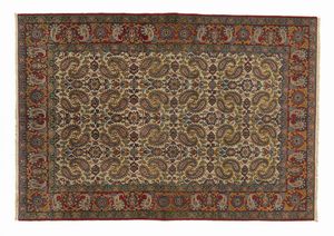 MANIFATTURA PERSIANA DEL XX SECOLO - Tappeto con fitte decorazioni fitomorfe in campo crema, incorniciato da fascia esterna nei toni del rosso