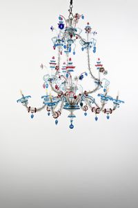 MANIFATTURA VENEZIANA DEL XX SECOLO - Lampadario in vetro di Murano incolore e policromo, arricchito da steli con corolle e decorazioni policrome