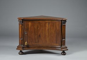 MANIFATTURA DEL XVIII-XIX SECOLO - Piccola angoliera lastronata in noce, anta singola sul fronte, elementi laterali in forma di colonne corinzie, piedi a trottola