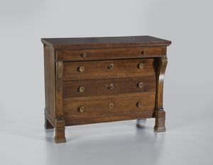 MANIFATTURA LOMBARDA DEL XIX SECOLO - Cassettone in stile Impero lastronato in noce con tre cassetti sul fronte e uno sottopiano, decorazioni laterali in legno dorato