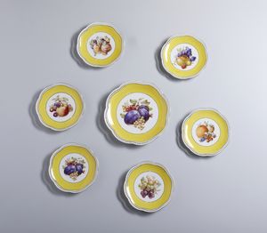 MANIFATTURA TEDESCA DEL XX SECOLO - Gruppo di sette piatti in porcellana a bordo mistilineo, centrati da natura morta di fiori su fondo bianco e giallo