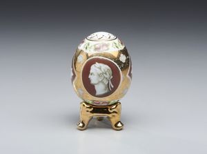 MANIFATTURA DEL XX SECOLO - Uovo in ceramica parzialmente dorata e dipinta, centrato da profilo di imperatore
