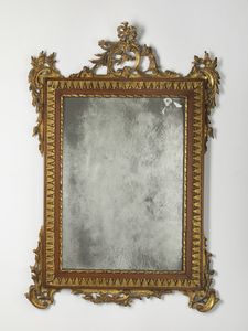 MANIFATTURA DEL XIX SECOLO - Specchiera in legno intagliato e dorato, battuta a nastro ritorto su gola seguita da bordo intagliato a motivi fogliacei, angoli e cimasa decorati a motivi vegetali