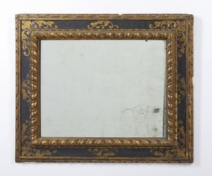 MANIFATTURA ITALIANA DEL XIX-XX SECOLO - Specchiera in cornice intagliata, laccata e parzialmente dorata nello stile del XVII secolo, angoli decorati da racemi dorati