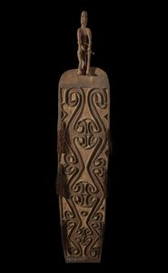 . - Scudo da guerra in legno inciso e dipinto arricchito da fibre vegetali, proveniente dalla cultura Asmat. Papua Nuova Guinea, XIX secolo.