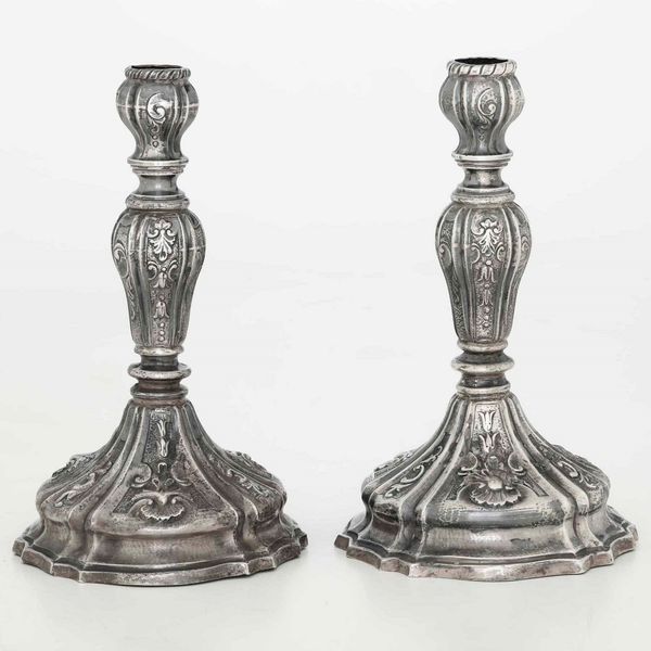 Coppia di candelieri in argento fuso, sbalzato e cesellato. Argenteria artistica del XX secolo. Apparentemente privi di punzonatura  - Asta Argenti - Associazione Nazionale - Case d'Asta italiane