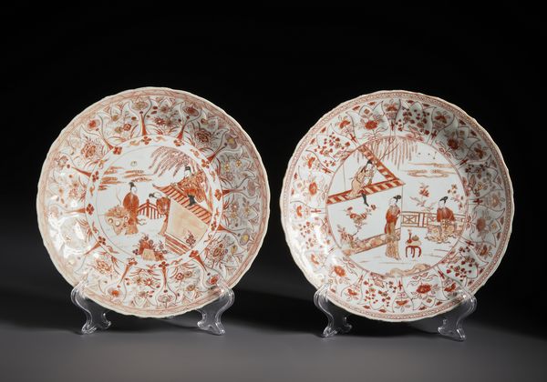 Arte Cinese : Due bei piatti in porcellana decorati in rosso ferro ed oro raffiguranti al centro scene tratte dal racconto �The Romance of the Western Chamber�. Cina, Dinastia Qing periodo Kangxi.  - Asta Asta 470 | ARTE ORIENTALE Online - Associazione Nazionale - Case d'Asta italiane